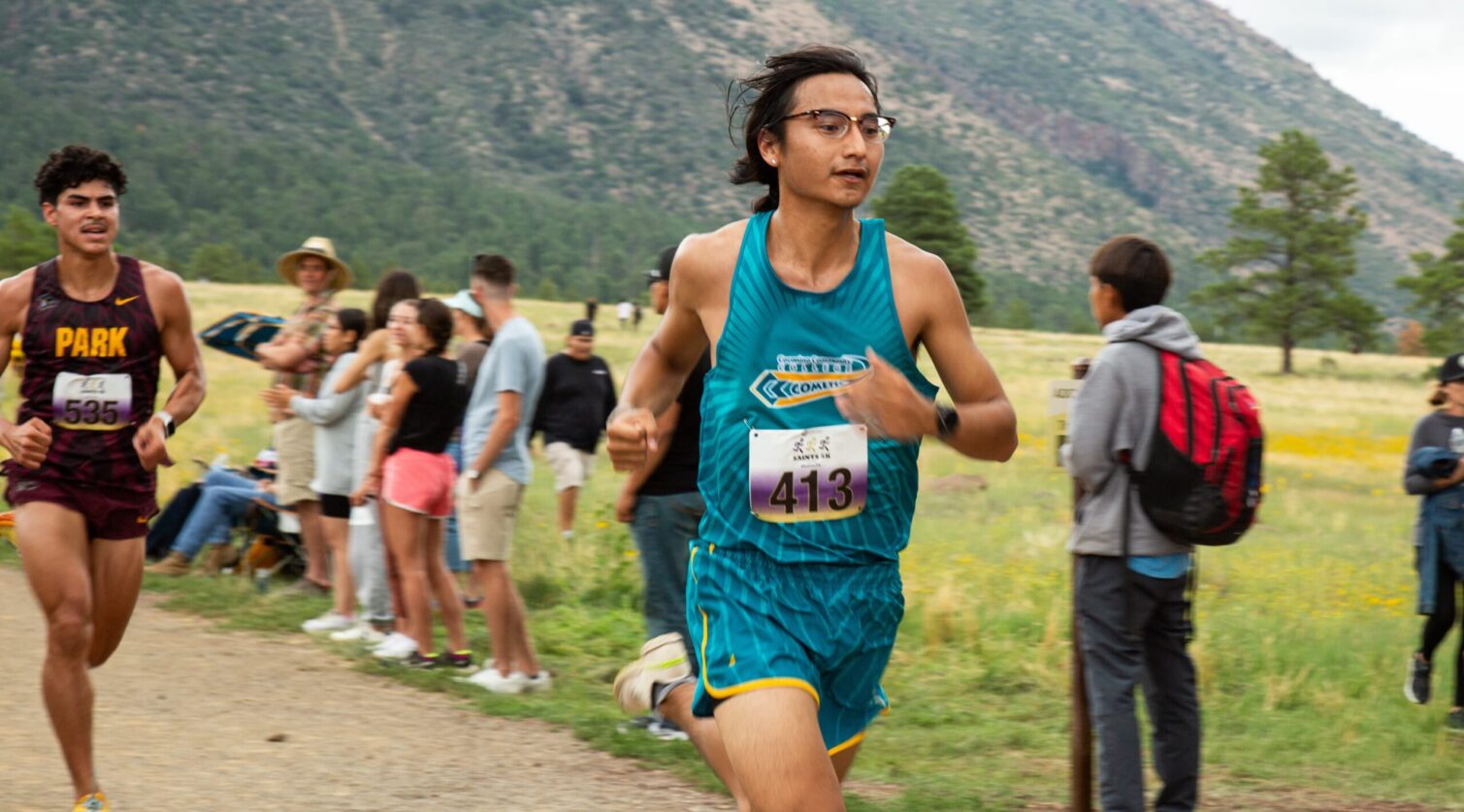 CCC athlete running down a dirt path during a cross country meet.