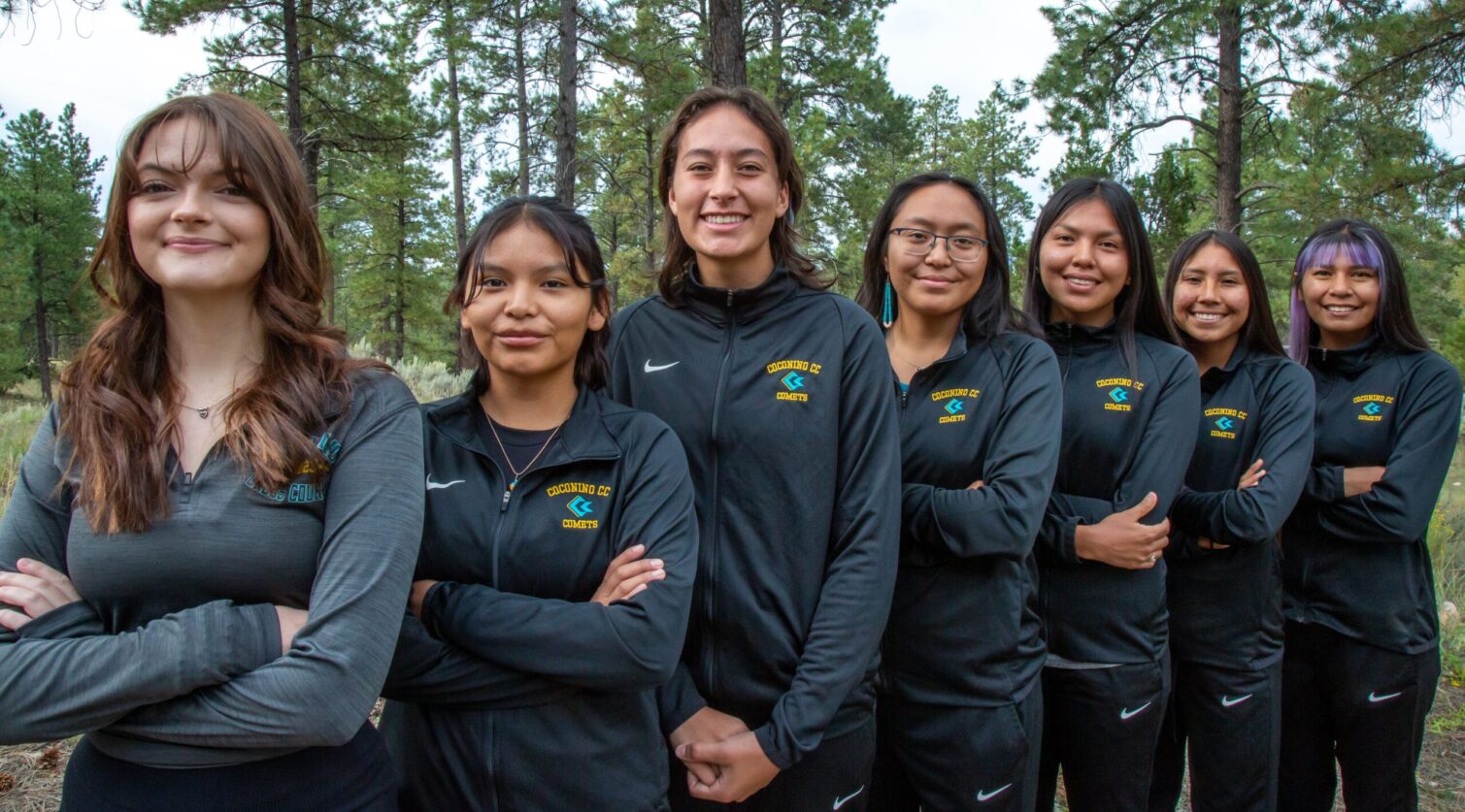 CCC's women's cross country team posing in their warm ups a team.