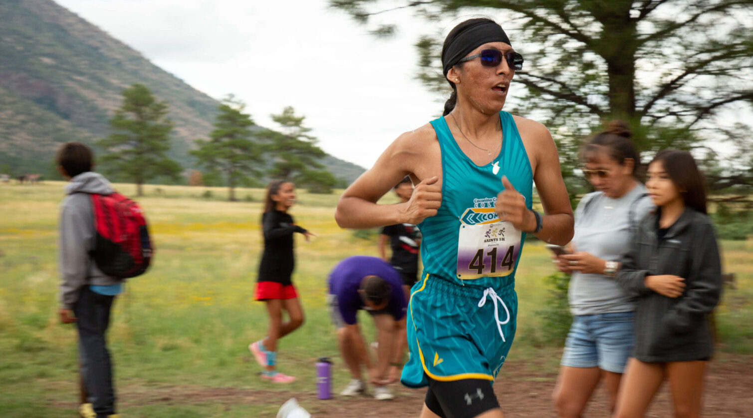 Male runner racing cross country.