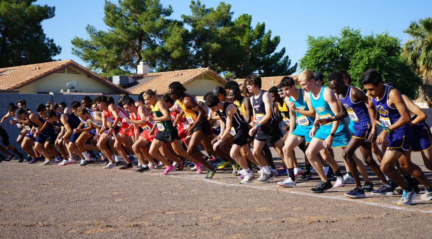 Runners take off from the starting line during a cross country race.