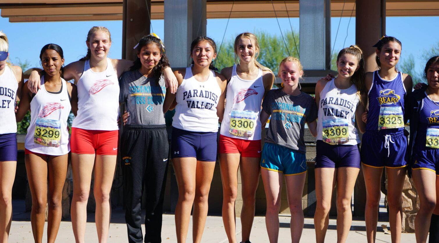 A group of female All-Region runners pose together with their arms around each other.