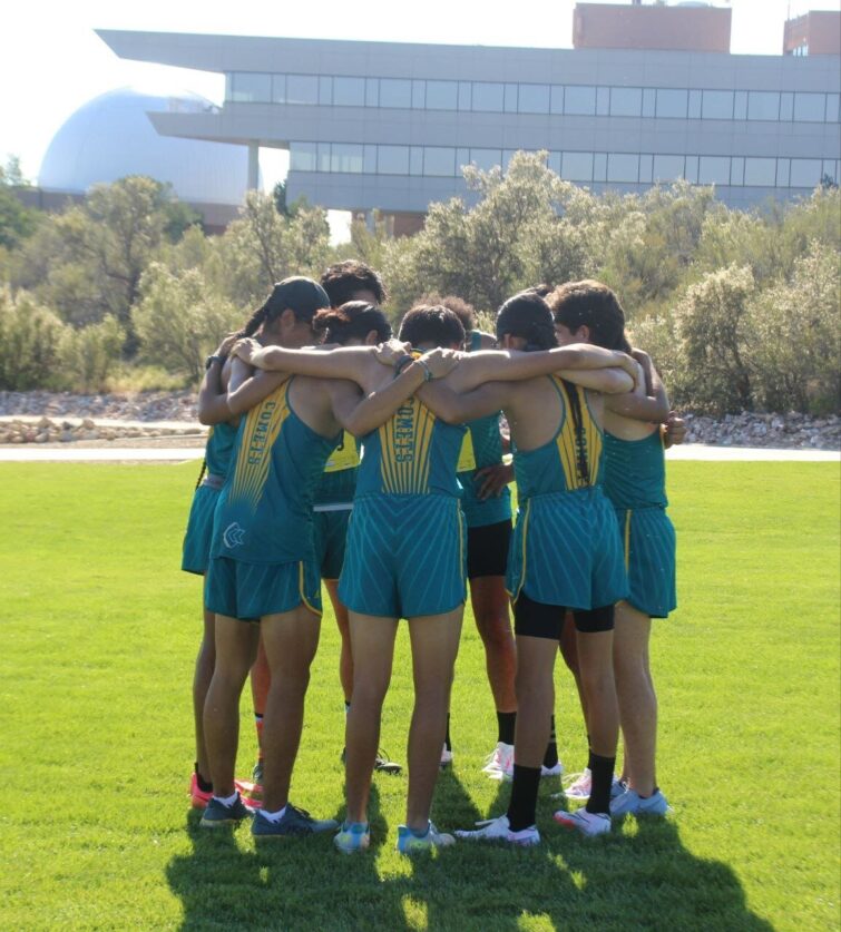 CCC's men's cross country team huddled up with their arms around eachother.
