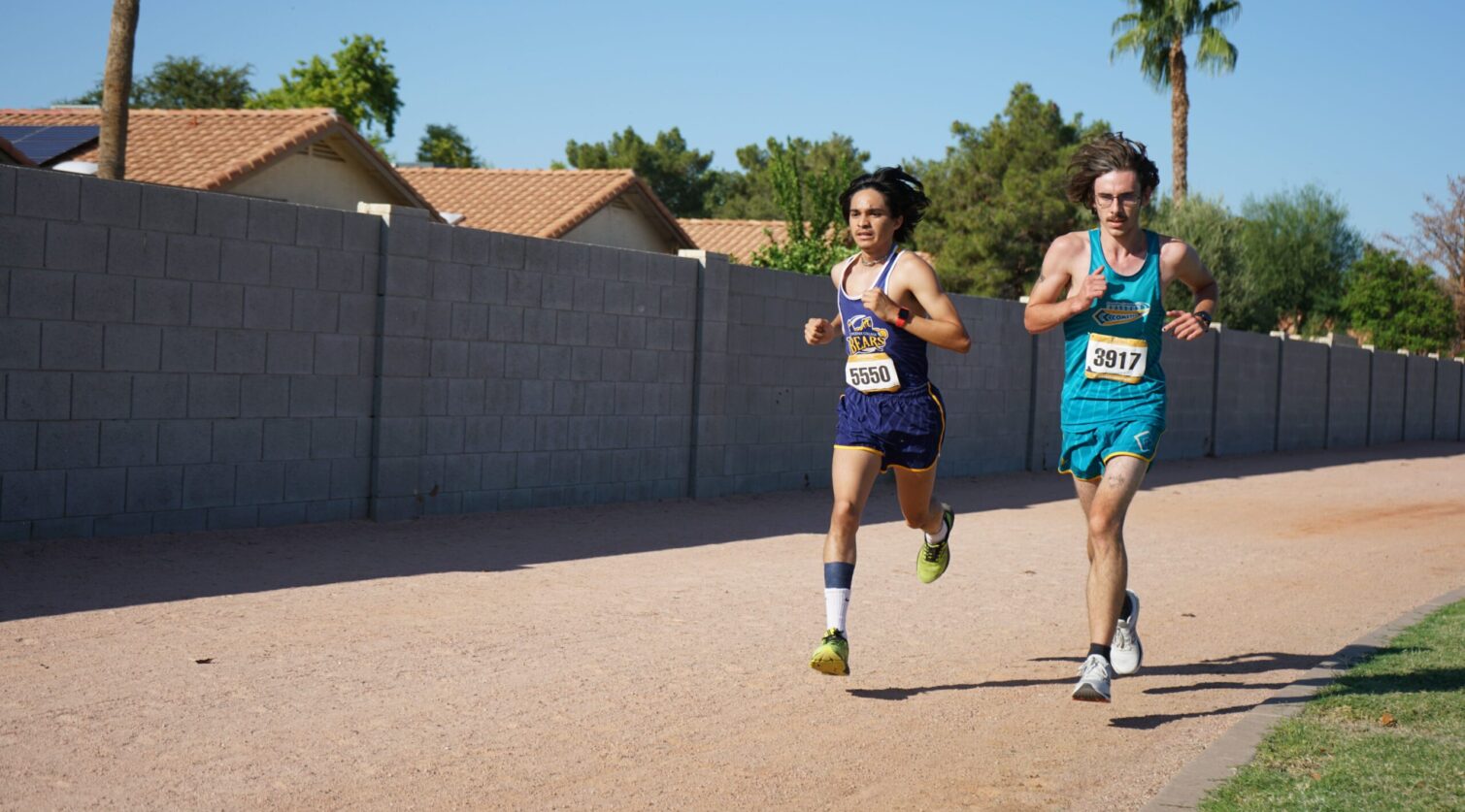 Two runners battling it out down a dirt path.