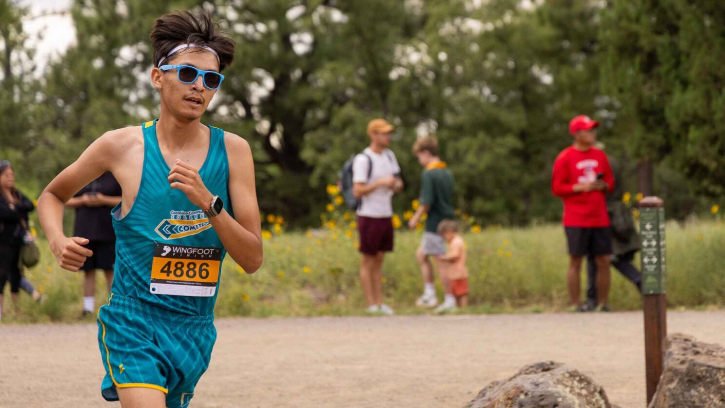 Male runner racing a cross country race.