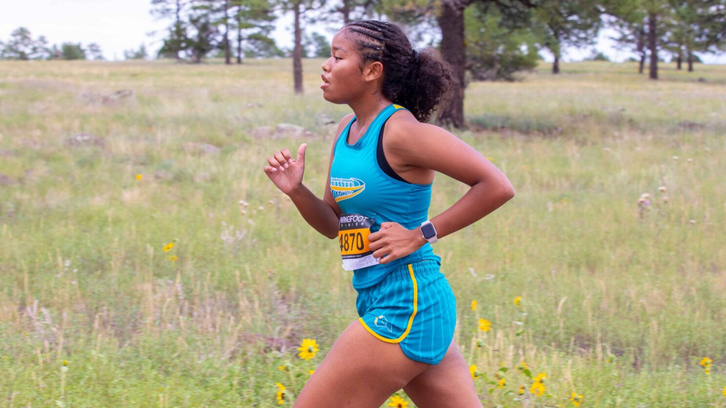 Female runner racing a cross country race.