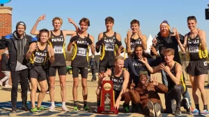 NAU Men's Cross Country posing as a team with their NCAA Championship trophy